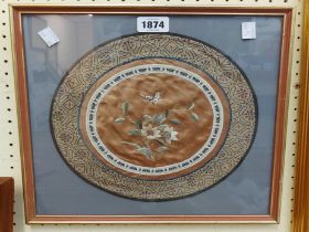 A framed 20th Century Chinese circular embroidered textile panel with central flowers and butterfly