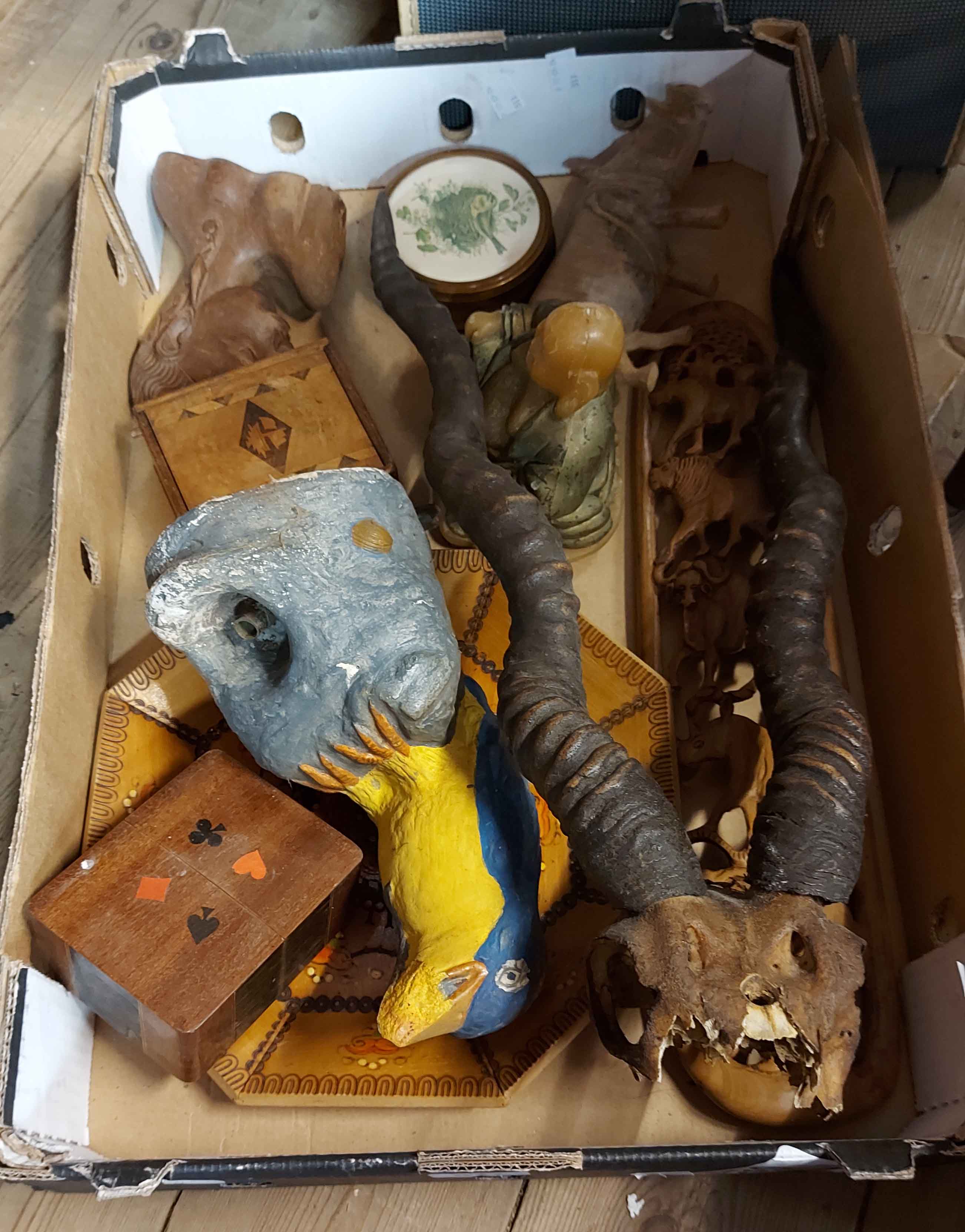 A box containing a quantity of collectable wooden items including a pair of mounted horns, a painted