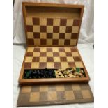 A wooden folding case containing an integral mixed wood chess board and a complete chess set -