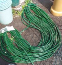 A green reinforced hose pipe - approximately 95m long