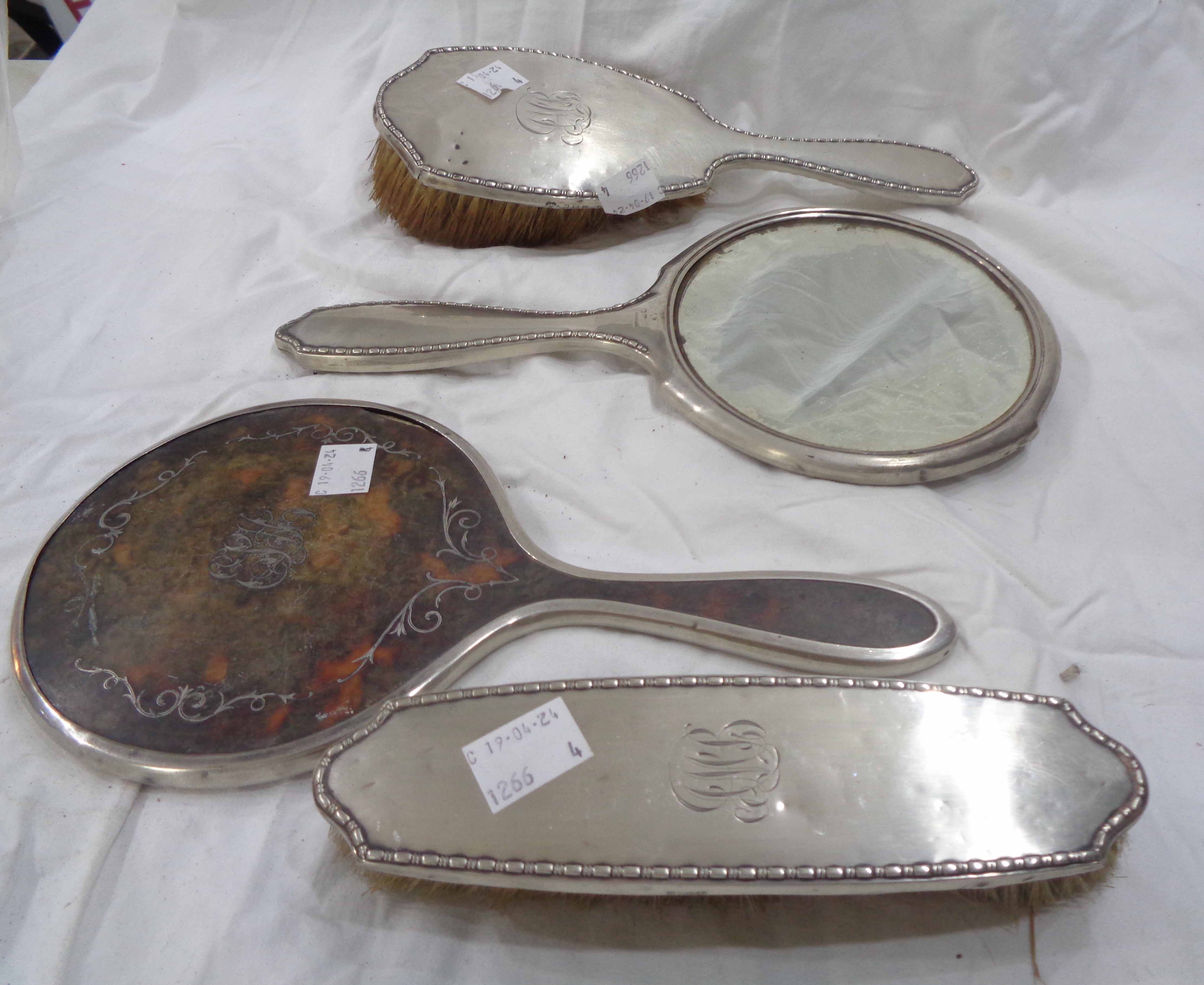 A silver backed hand mirror and two brush set with engraved initials - sold with another silver