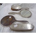 A silver backed hand mirror and two brush set with engraved initials - sold with another silver