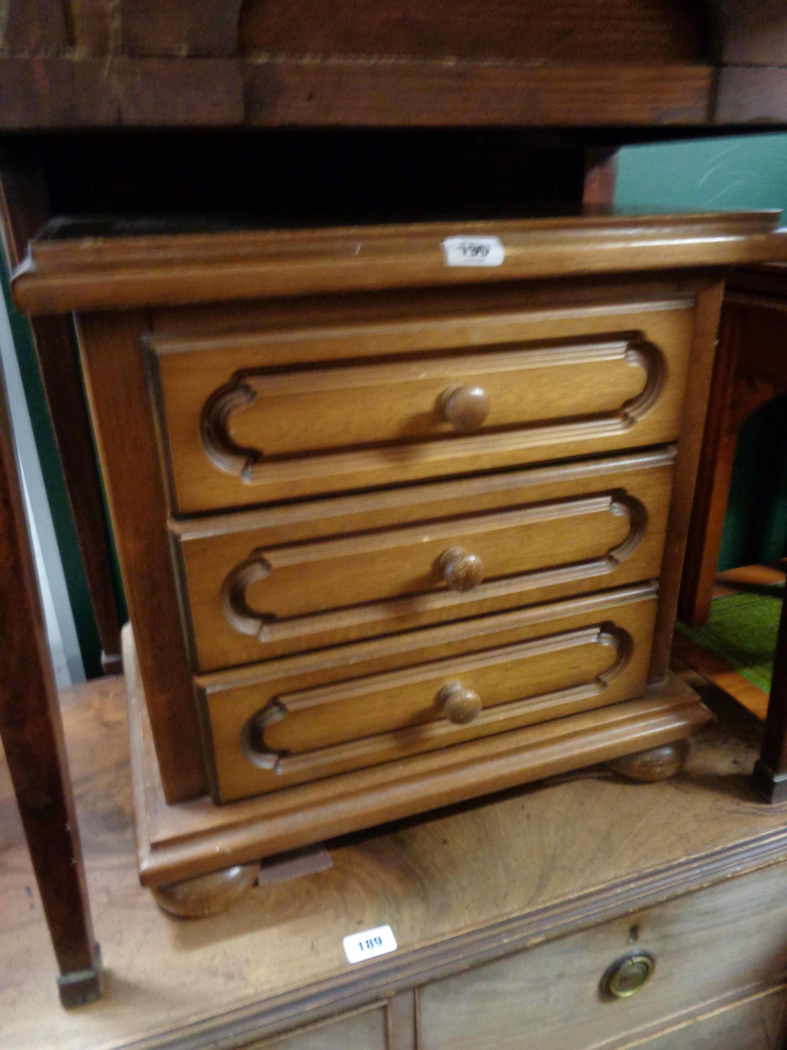 A 20th Century oak three drawer bedside chest - sold with a reproduction nest of three tea tables