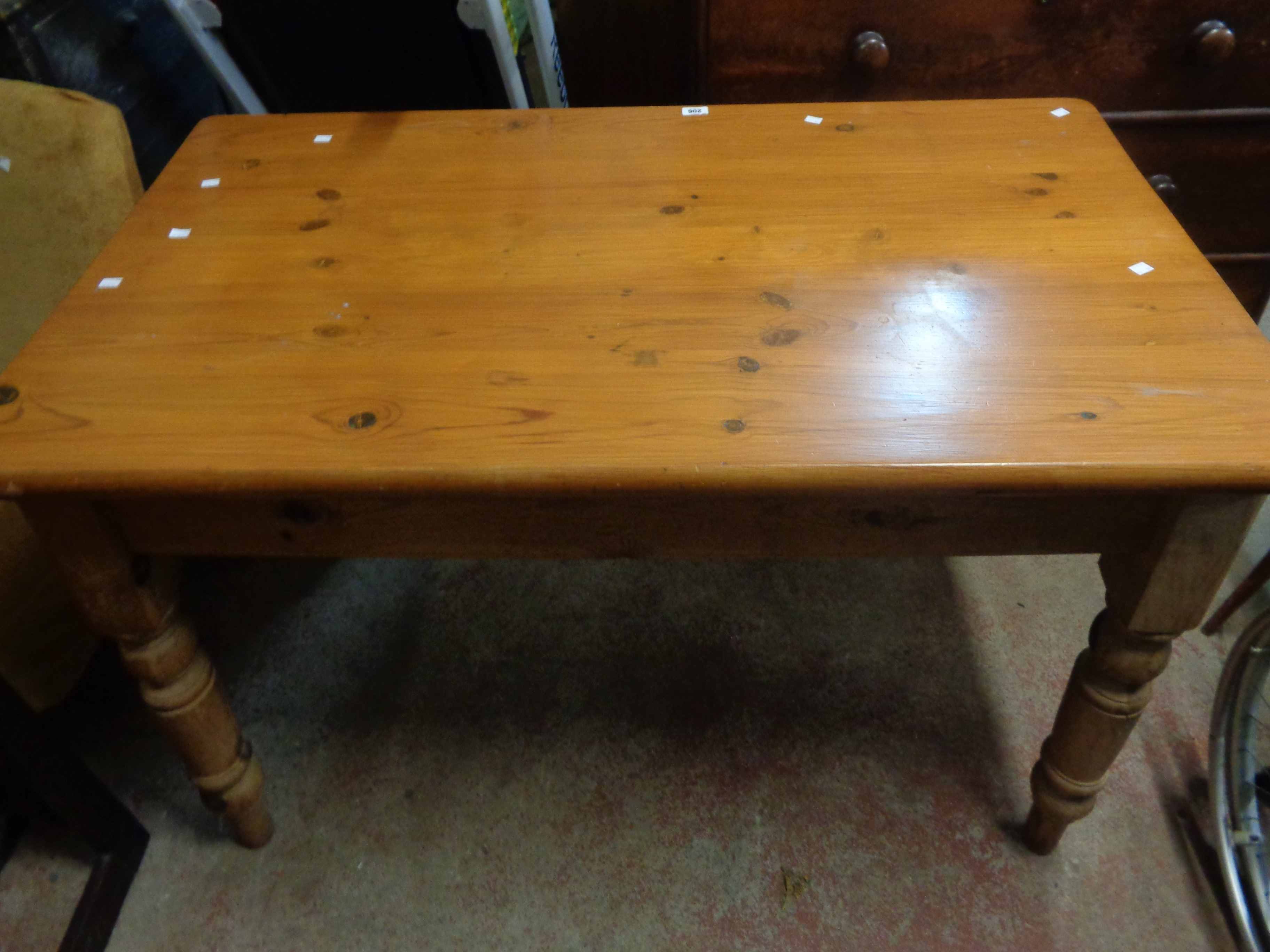 A 1.35m modern pine kitchen table, set on turned legs