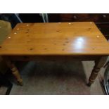 A 1.35m modern pine kitchen table, set on turned legs