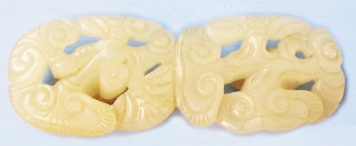 An antique Chinese carved white jade coat toggle with pierced scroll decoration