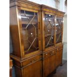 A 1.38m reproduction yew wood two part break front book cabinet with shelves enclosed by a pair of