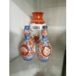 A pair of small old Japanese Imari vases of globe bottle form with painted decoration - sold with