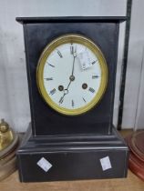 A late Victorian black slate cased mantel clock with eight day striking movement