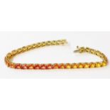A 375 (9ct.) gold tennis/inline bracelet, each of the links set with an individual yellow, orange