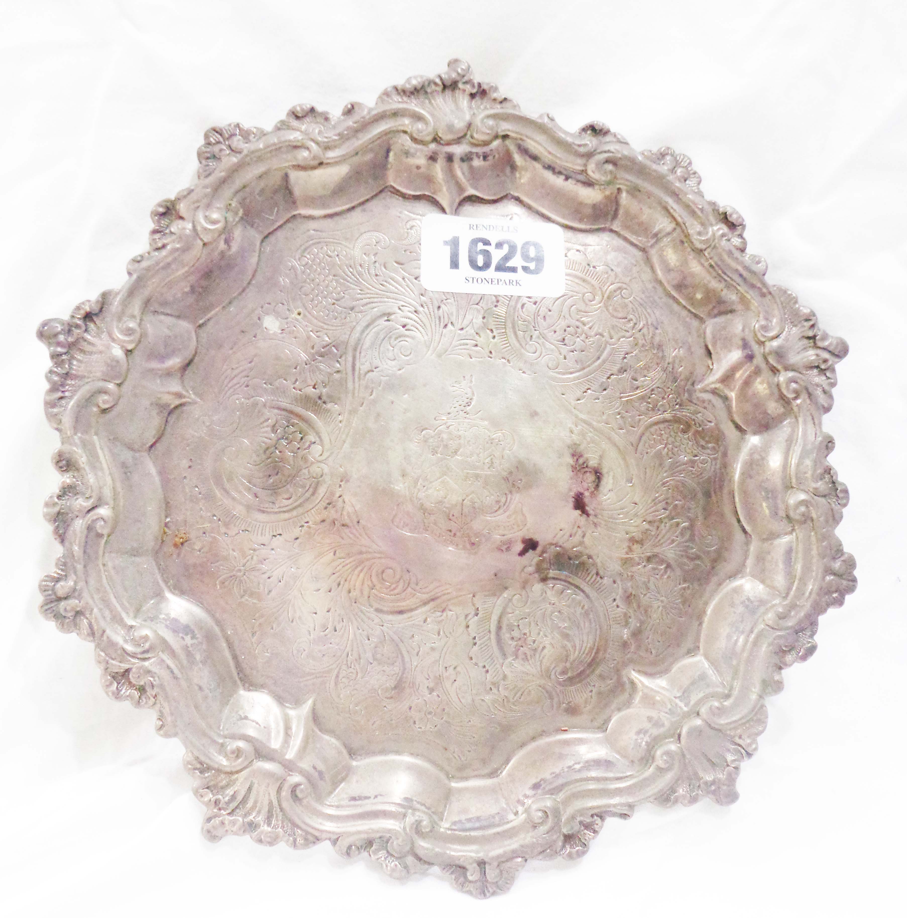 A 21cm diameter silver salver with central armourial and engraved decoration, Rococo cast rim and