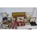 A box containing a quantity of silver plated items including entree dishes, cased and loose cutlery,