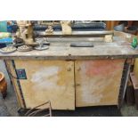 A woodworking lathe set on workshop counter cabinet