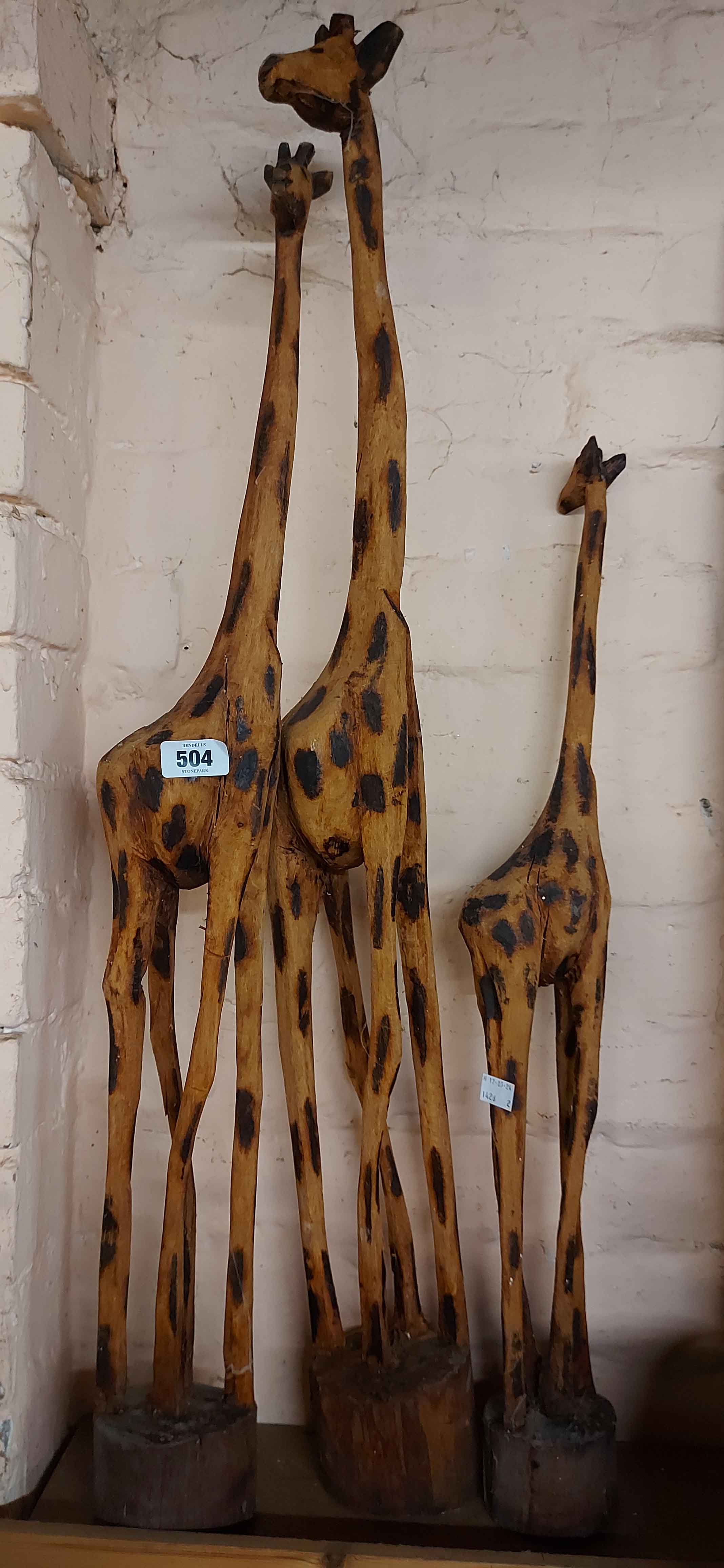 Three carved wood giraffe figures