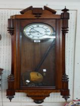 An early 20th Century stained walnut cased Vienna style regulator wall clock with visible pendulum