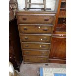 A 61cm vintage oak chest with flight of six long graduated drawers, each with red Bakelite