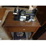 A vintage oak cased Frisster & Rossman electric sewing machine, set on casters