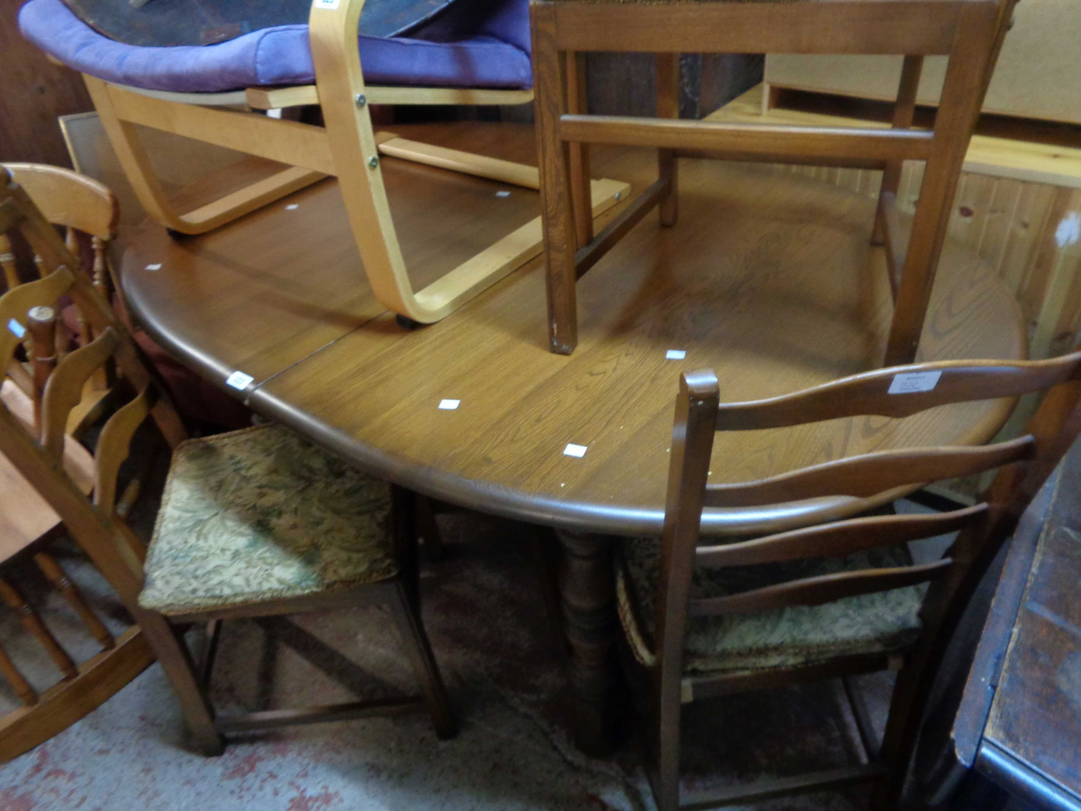 A 1.6m vintage Ercol elm extending dining table with stowed folding leaf, set on turned supports -
