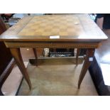 A Sorrento ware lift-top games table with musical movement