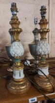 A pair of painted giltwood candlestick style lamps with pineapple decoration