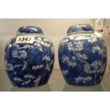 A pair of Chinese porcelain ginger jars and lids with painted blue prunus decoration - six character