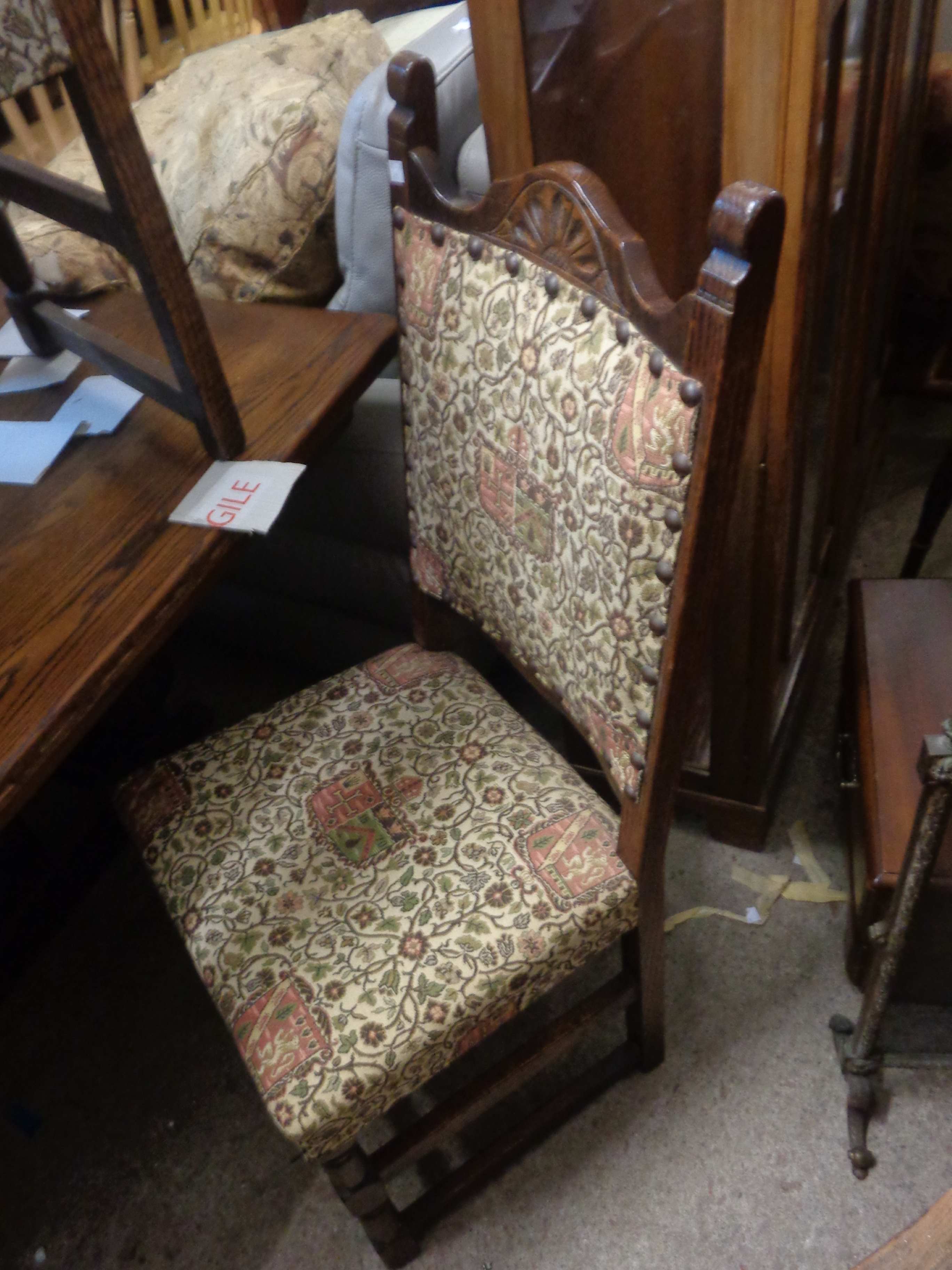 A set of six vintage oak panel back dining chairs with upholstered backs and seats, comprising