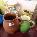Four pottery jugs comprising terracotta milk jug, slip glazed jug of bulbous form, green glazed