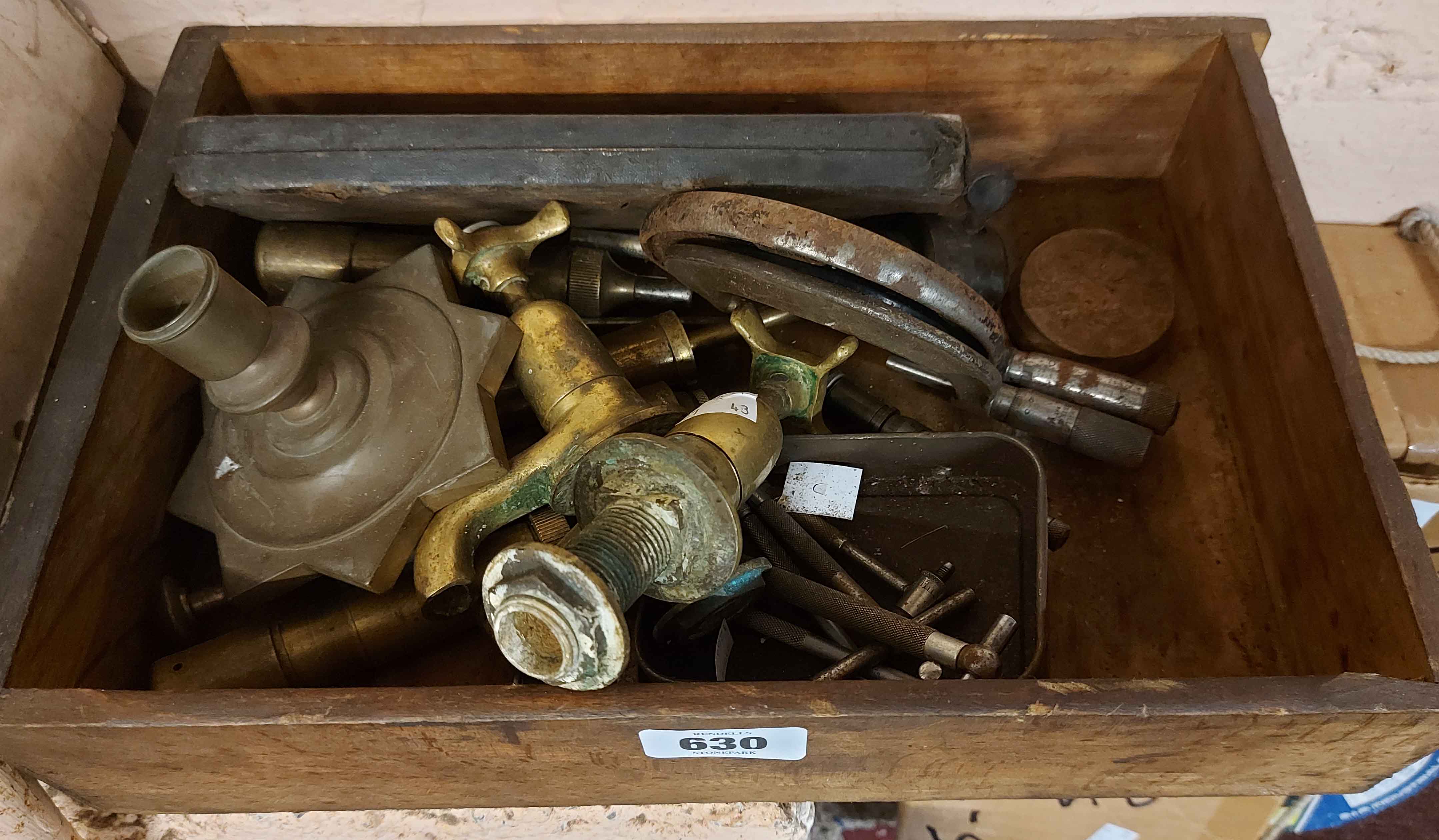 A box containing micrometers, grease guns and brass taps