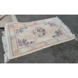 A modern machine made Chinese wash wool rug with dragon decoration on cream ground