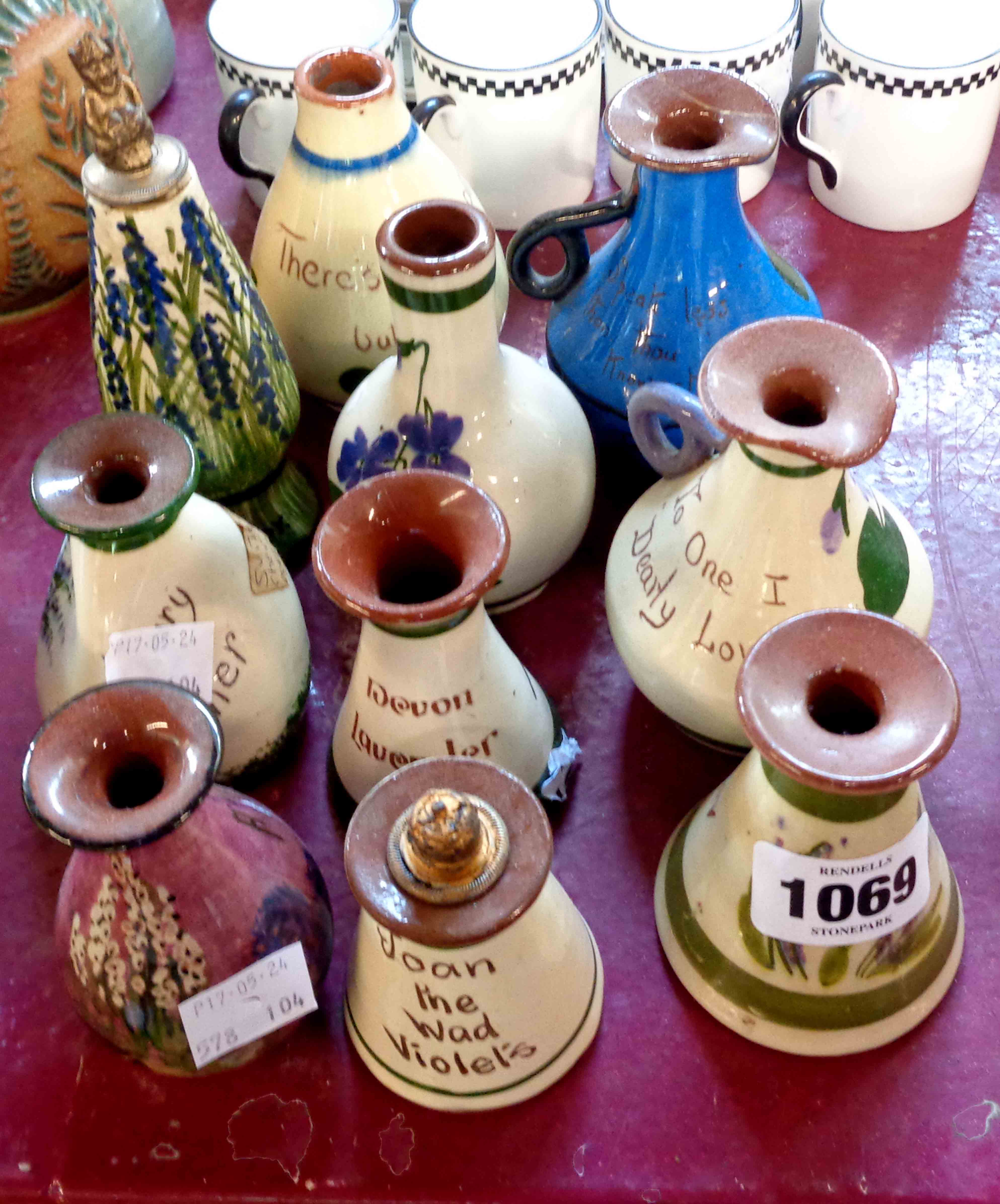 Ten Torquay Pottery scent bottles of various form and maker including one with 'pixie' stopper