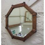 An early 20th Century copper clad framed octagonal wall mirror with beaten border and bevelled