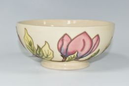 A MOORCROFT POTTERY 'MAGNOLIA' PATTERN BOWL, of footed form, tube lined with pink magnolias, on a