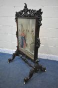 A VICTORIAN WALNUT FIRE SCREEN, the heavily carved frame with scrolling and foliage, on shaped