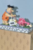A BOXED ENESCO 'THE FLINTSTONES' FIGURINE, by Jim Shore 4058333 Fred Flintstone 'Mower-A-Saurus' (1)