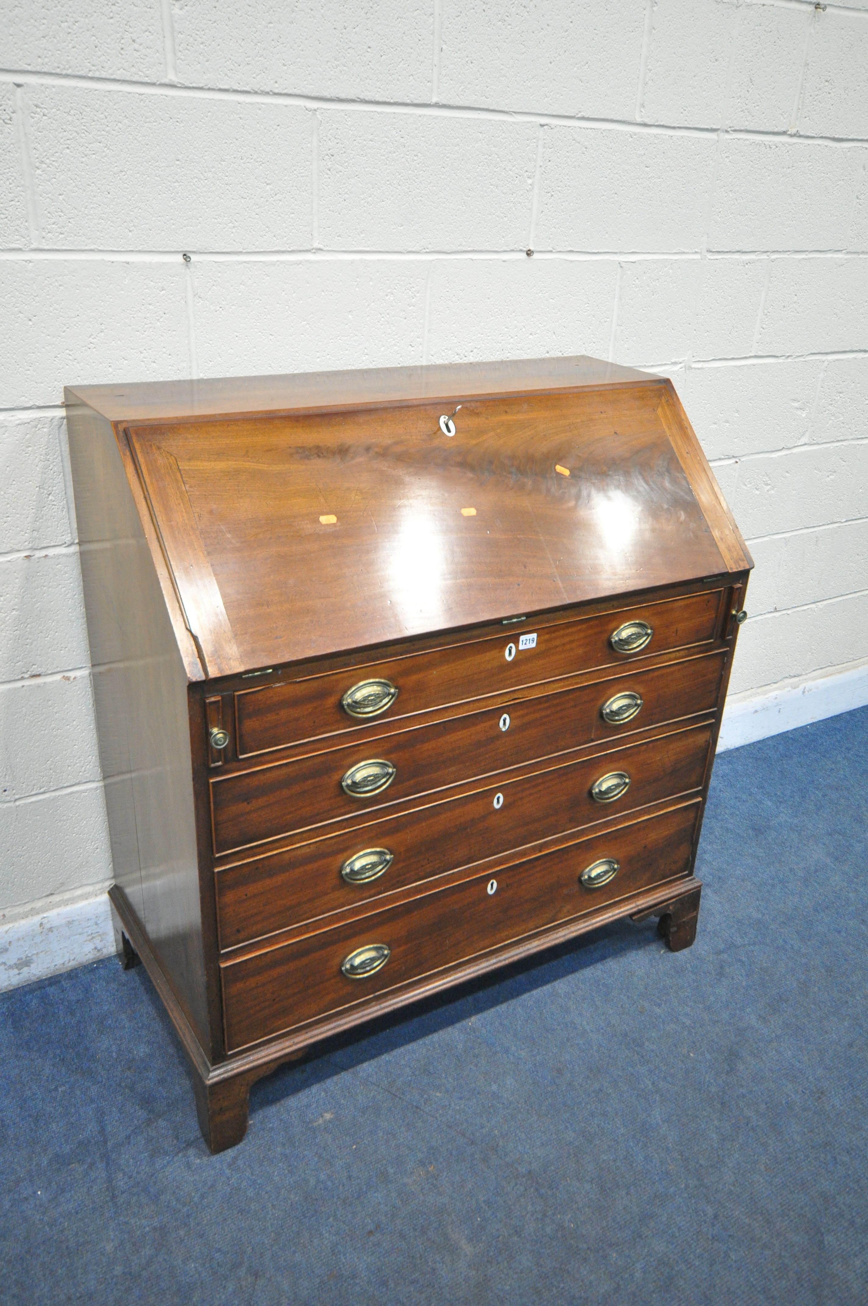 A GEORGIAN MAHOGANY BUREAU, the fall front door enclosing a fitted interior, above four drawers,