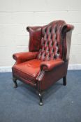AN OXBLOOD LEATHER CHESTERFIELD WING BACK ARMCHAIR, on front cabriole legs, width 81cm x depth