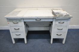A WHITE PAINTED SECRETARY DESK, fitted with two brushing slides, six drawers, flanking an
