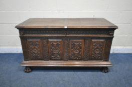 A GEORGIAN AND LATER OAK COFFER, with a hinged lid, twin mask carving, geometric and foliate panels,