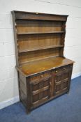 A DARK ERCOL DRESSER, the top two tier plate rack above two drawers and two cupboard doors, width