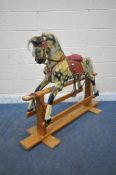 AN EARLY 20TH CENTURY PLAYWORN DAPPLED CHILDS ROCKING HORSE, with leatherette and upholstered saddle