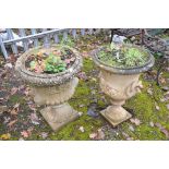 TWO COMPOSITE CAMPAGNA GARDEN URNS, one with twin mask effect handles height 85cm, the other with