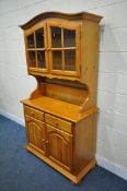 A MODERN PINE DRESSER, the domed top with two glazed doors, the base with two drawers and two