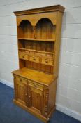 A 20TH CENTURY PINE DRESSER, the top fitted with two shelves and three drawers, the base with two