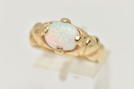 A YELLOW METAL SYNTHETIC OPAL RING, oval synthetic opal cabochon, in a four claw setting, textured