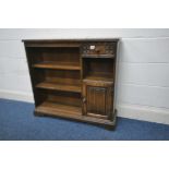 AN OLD CHARM OAK OPEN BOOKCASE, fitted with an arrangement of three shelves, a single drawer and