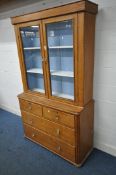 A VICTORIAN PITCH PINE BOOKCASE, the top with double glazed doors, enclosing two shelves and painted