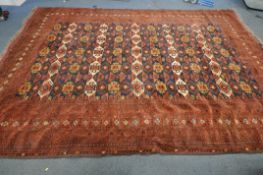 A LARGE AFGHAN RED WOOLLEN RUG, with central repeating geometric pattern, and multi strap border,