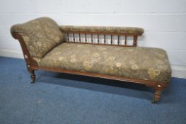 A VICTORIAN OAK FRAMED CHAISE LOUNGE, with foliate upholstery, turned supports and legs, on brass