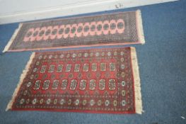 A PINK BOKHARA RUNNER, with fifteen medallions and a multi strap border, 183cm x depth 64cm, along