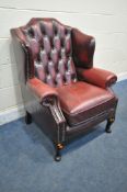 A BURGUNDY UPHOLSTERED CHESTERFIELD BUTTONED WING BACK ARMCHAIR, width
